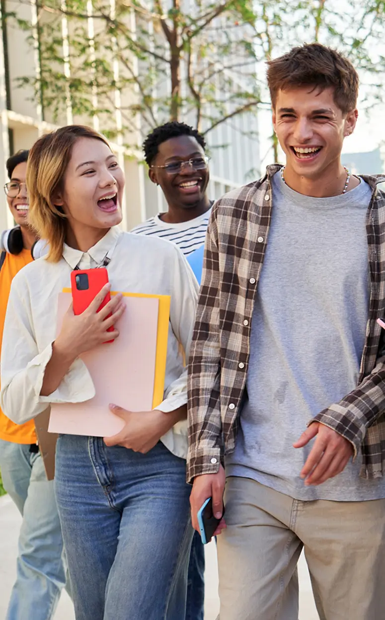 four students walking together and smiling
