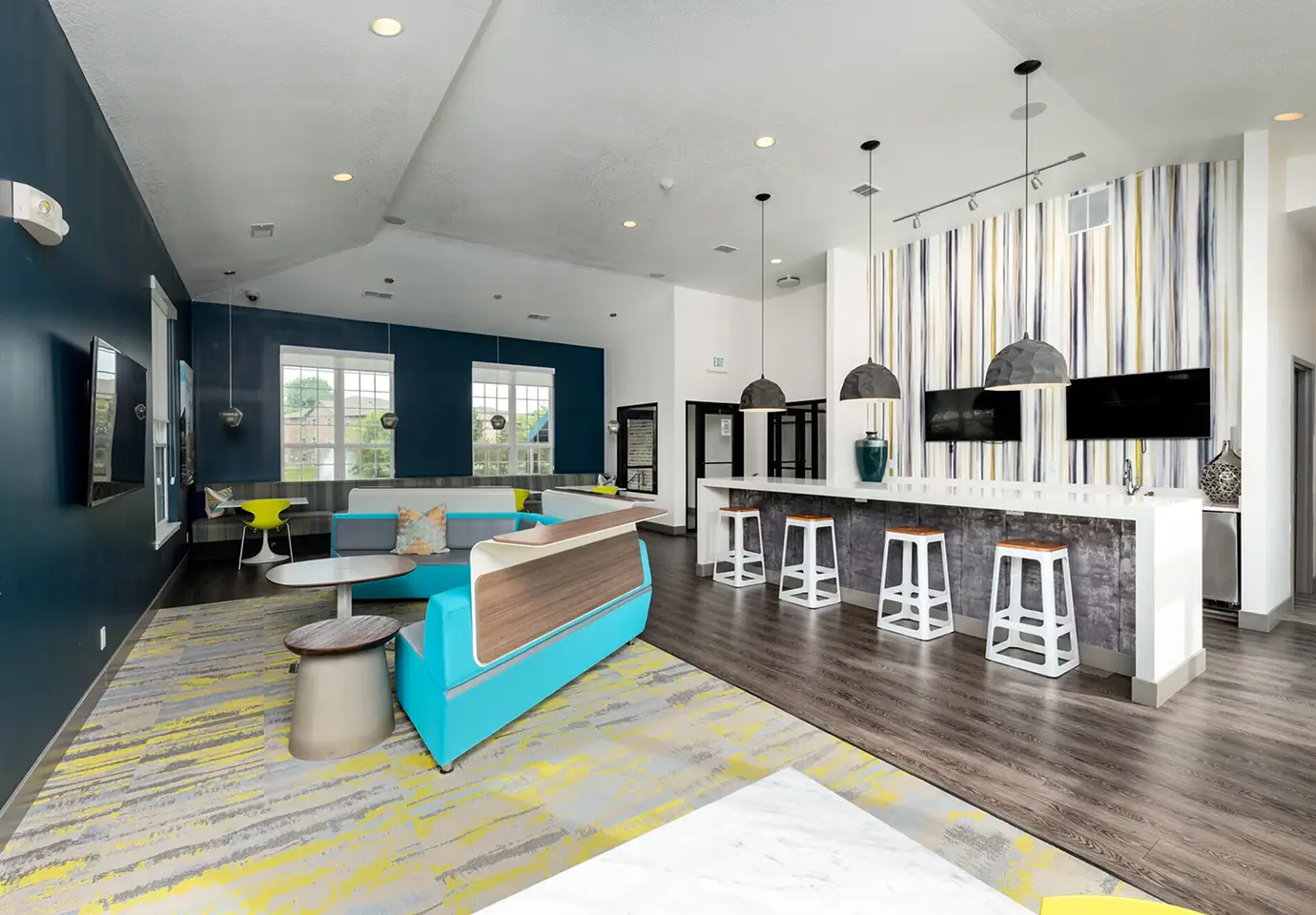 apartment community lounge with couches, tvs, and a bar