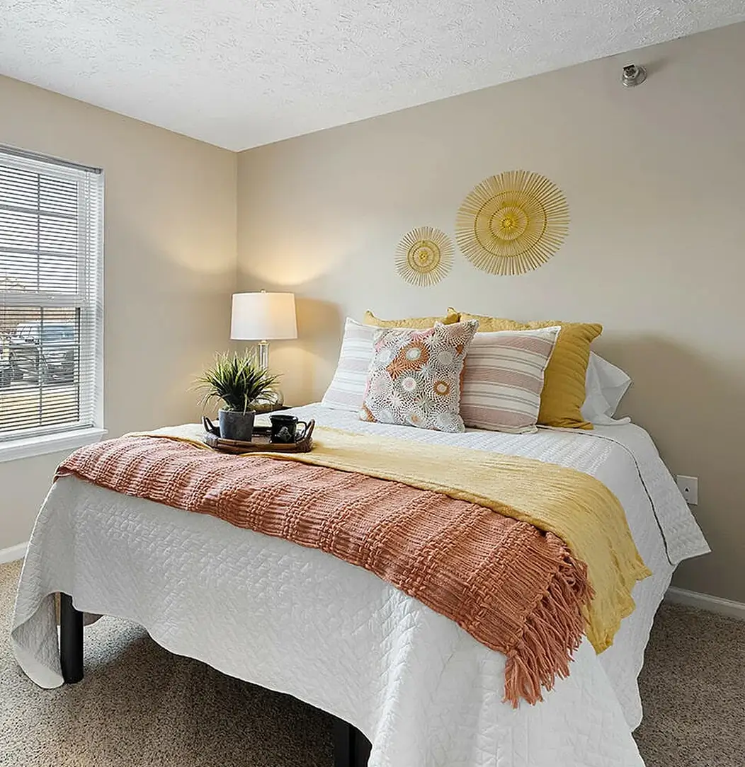 Apartment bedroom with queen bed and stylish bedding
